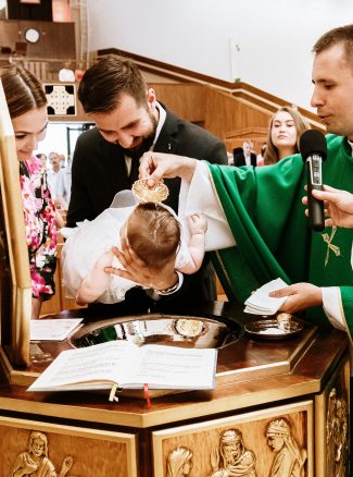 ceremonia chrztu, ksiądz polewa wodą święconą głowę niemowlęcia